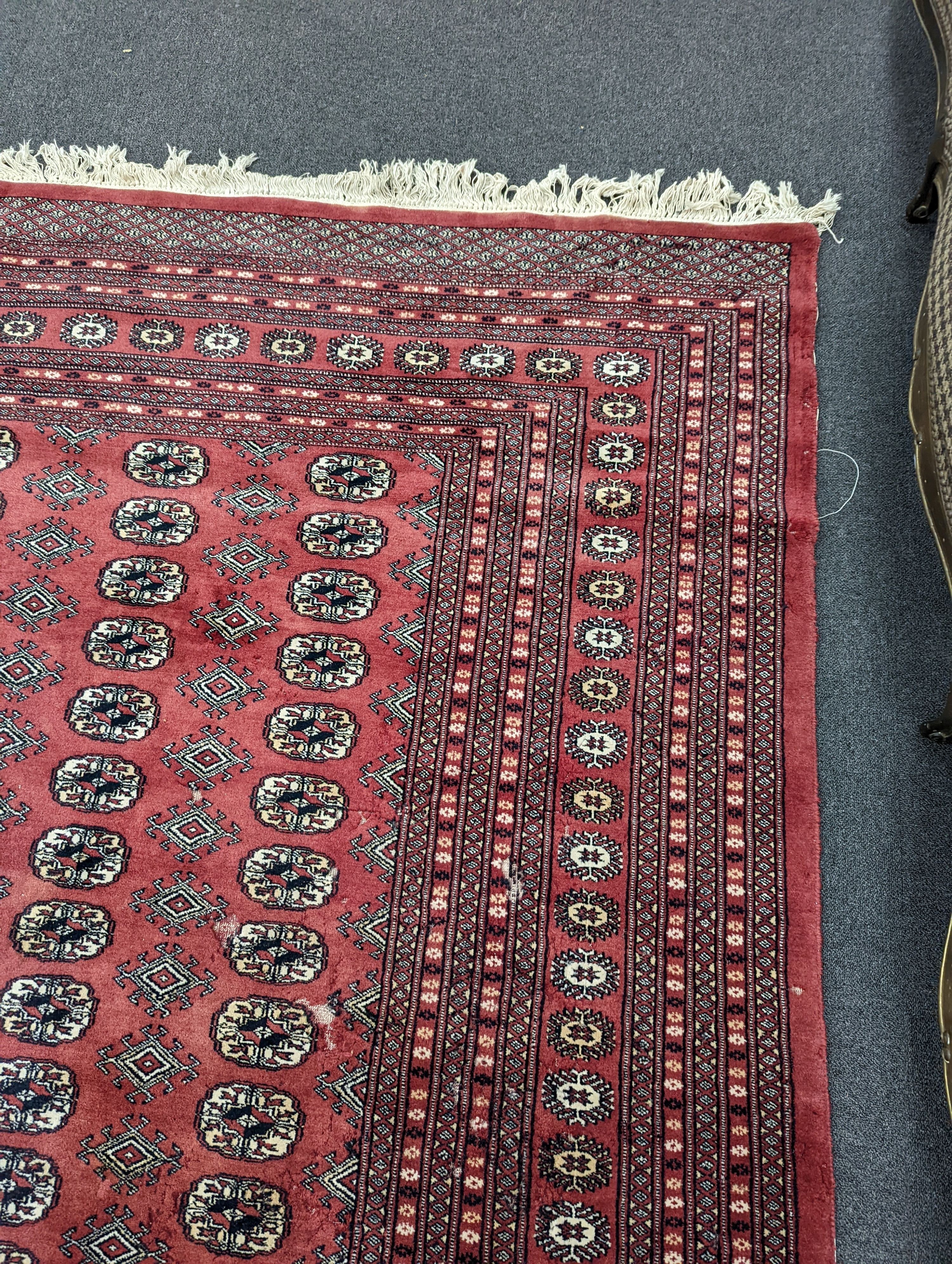 A Bokhara burgundy ground carpet, 360 x 276cm